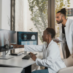 Two doctors analyzing medical images on computer monitors