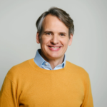 Professional portrait of Dr. Philip Heiman, Managing Director and co-founder ViViRA in a mustard yellow sweater