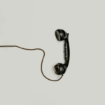 Vintage telephone with loose cord on a light background