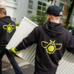 Workers carrying radiators wearing ScrapBees hoodies.